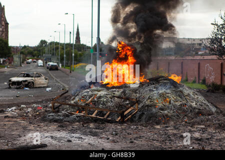 Divis Street, Belfast, Royaume-Uni. 9 août 2016. Une voiture se trouve près du feu dans Anti-Interment la Divis Street, Belfast qui brûlait encore huit heures après avoir été allumé. Il y a eu une peur que trois véhicules volés sur la 8e nuit. Le feu à l'occasion du renvoi controversé sans frais des hommes principalement catholiques le 9 août 1971. Credit : Bonzo/Alamy Live News Banque D'Images