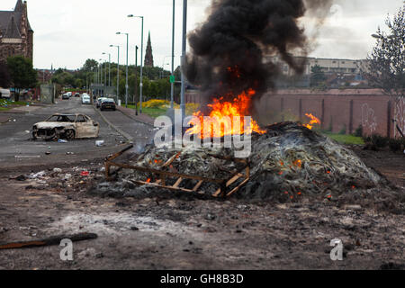 Divis Street, Belfast, Royaume-Uni. 9 août 2016. Une voiture se trouve près du feu dans Anti-Interment la Divis Street, Belfast qui brûlait encore huit heures après avoir été allumé. Il y a eu une peur que trois véhicules volés sur la 8e nuit. Le feu à l'occasion du renvoi controversé sans frais des hommes principalement catholiques le 9 août 1971. Credit : Bonzo/Alamy Live News Banque D'Images