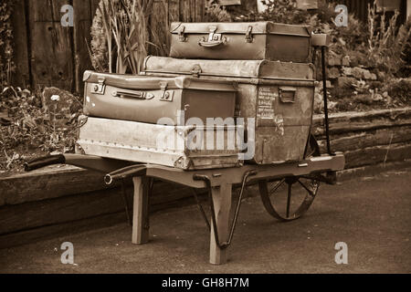 Image sépia de vieux bagages sur le panier sur la plate-forme de la gare Ashford, Kent et l'East Sussex Railway. Banque D'Images