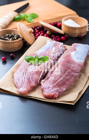 Filet de porc cru sur du papier craft prêt à cuire Banque D'Images
