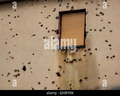 Mur du bâtiment à Mostar criblée avec shell de missiles et trous de balle autour de fenêtre après la guerre civile en Bosnie et Herzégovine Banque D'Images