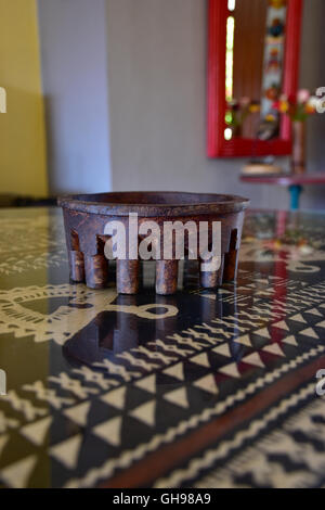 Tanoa Samoan antique ou laulau le kava bol sculpté dans du bois. Tapa Samoan chiffon sous verre sur table. Banque D'Images