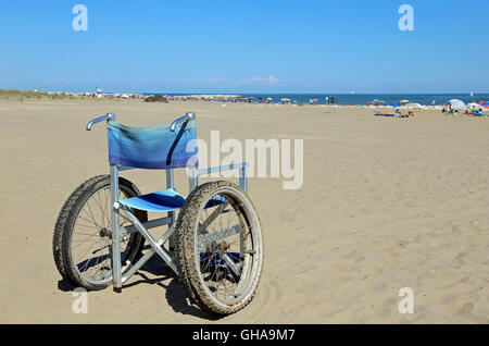 Fauteuil roulant isolé pour les personnes ayant des problèmes de mobilité sur la mer la plage en été Banque D'Images