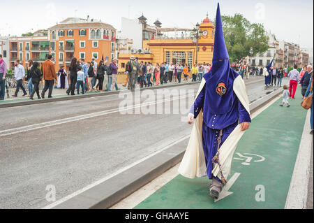 Séville Pâques, membre d'un cofradia à capuche (fraternité) marche pour assister à sa procession dans le festival de la semaine Sainte de Pâques à Séville, Espagne. Banque D'Images