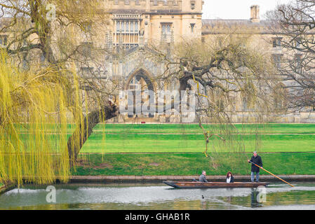 Sur un début de matinée de printemps à Cambridge, UK, les touristes prendre un voyage dans un punt sur la rivière Cam, vol libre passé St Johns College. Banque D'Images