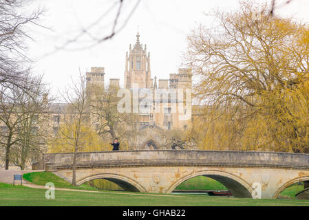 Un touriste japonais lui-même des photos sur le pont de la Trinité contre l'arrière-goutte de St John's College, Cambridge, UK. Banque D'Images