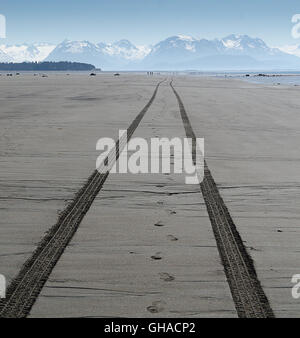 Les traces de pneus VTT s'étendent dans la distance sur une plage solitaire Banque D'Images