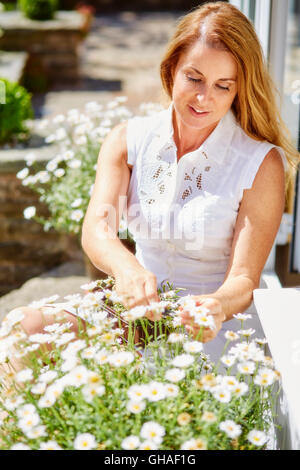 Femme fleurs de fraisage extérieur Banque D'Images