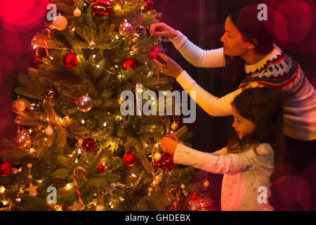 Mère et fille decorating Christmas Tree Banque D'Images