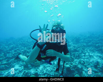 Portrait de scuba diver gesturing okay underwater Banque D'Images