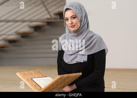 Belle femme musulmane portant le hijab et la lecture du Coran Banque D'Images