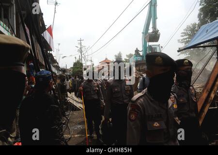 Jakarta, Indonésie. 28 Sep, 2016. Les agents de police de recueillir le plus d'une excavatrice qui démolit les maisons à Bukit Duri, un bidonville à Jakarta, Indonésie, le 28 septembre 2016. L'administration de la ville de Jakarta a commencé à expulser les résidents et démolir des maisons à Bukit Duri, un bidonville sur les rives de la rivière Ciliwung, pour faire place à la rivière Ciliwung programme d'atténuation des inondations. Ti'Kucahya Crédit : B./Xinhua/Alamy Live News Banque D'Images