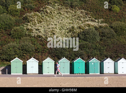 Bournemouth, Dorset, UK. 28 septembre 2016. Runner passé en courant les tons de vert cabines de plage le long de la promenade de diverses nuances de vert feuillage vert avec arrière-plan sur une chaude journée ensoleillée. Credit : Carolyn Jenkins/Alamy Live News Banque D'Images