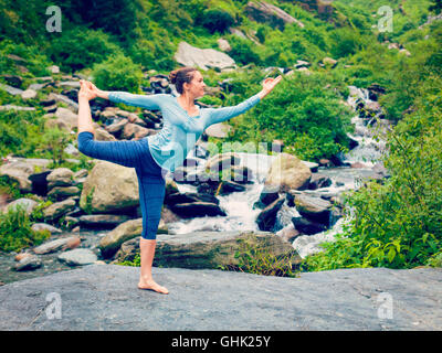 Woman doing yoga asana Natarajasana dehors à la cascade Banque D'Images