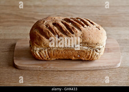 Close-up grosse miche de pain de blé sur planche à découper en bois Banque D'Images