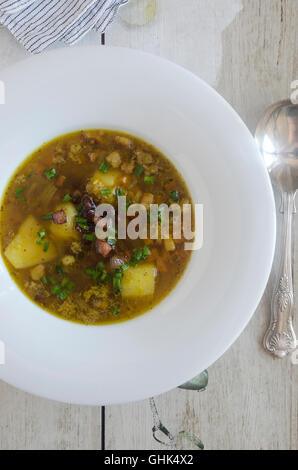 Soupe de lentilles et lard surmontée de ciboulette Banque D'Images