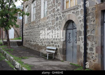 L'Arménie Goris siège sur l'extérieur de la chaussée double porte principale dans la maison et le jardin autour de pointage lourd basalte pierre Banque D'Images