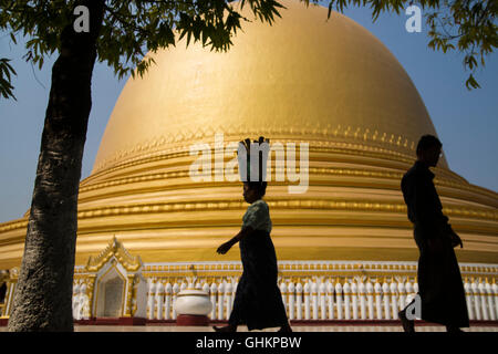 Femme marche et l'exercice sur l'élément head silhouette sur le dôme d'or de la Pagode Kaunghmudaw, Myanmar Banque D'Images