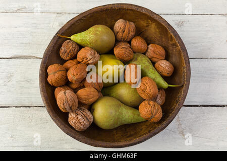 Automne Nature morte avec un bol de poires et les noix sur une grunge background Banque D'Images