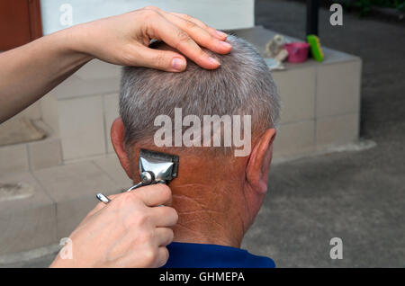 Salon de coiffure improvisé sur une ferme rurale. Films pour la femme un homme après la récolte avant de se baigner dans la baignoire Banque D'Images