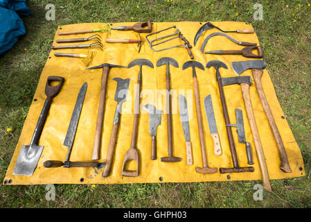 Outils de jardinage anciens disposés sur une feuille jaune à vendre à un vide grenier Banque D'Images