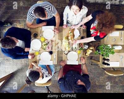 Groupe d'amis en train de déjeuner au restaurant Banque D'Images