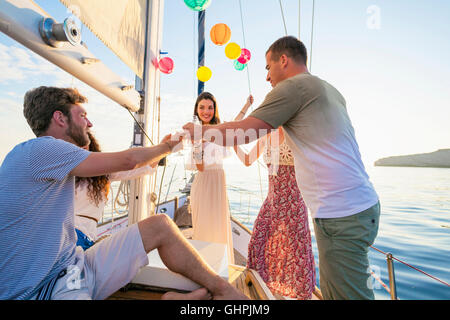 Friends toasting wine glasses on voilier Banque D'Images