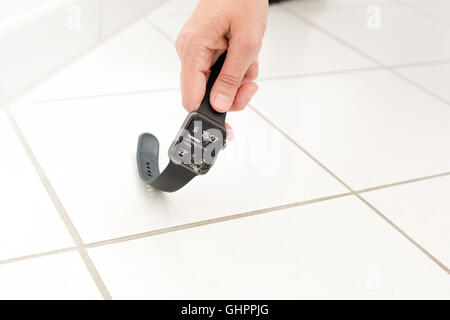 Woman picking up a broken Watch Apple Banque D'Images