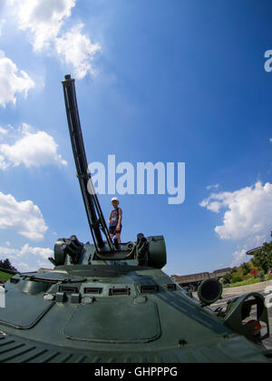 Garçon jouant sur un véhicule de transport de troupes dans le cadre d'une exposition au Musée de la Seconde Guerre mondiale, Kiev, Ukraine Banque D'Images