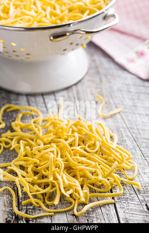 Pâtes spaetzle savoureux sur la vieille table de cuisine. Banque D'Images