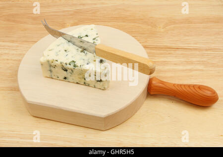 Coin de fromage bleu danois avec un couteau à fromage sur un billot en bois Banque D'Images