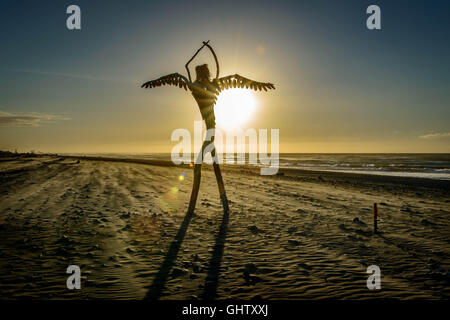 Hokitika, la Nouvelle-Zélande. Feb 9, 2016. Hokitika, New Zealand - 9 février 2016 - Un ange en bois inconnu, un reste de la plage de sable et de bois flotté Sculpture événement qui a eu lieu deux semaines plus tôt, est vu pendant le coucher du soleil le 9 février 2016 à Hokitika, la Nouvelle-Zélande. Dans le monde d'utilisation | © dpa/Alamy Live News Banque D'Images