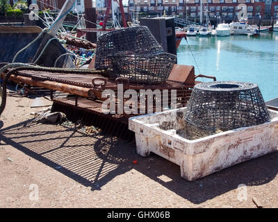 Des casiers à crabe et homard le long avec de vieux engins de chalutage sur le quai. Banque D'Images