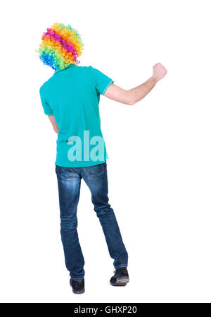 Vue arrière de la danse jeune bel homme perruque de clown. Banque D'Images