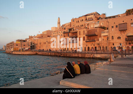 Israël : une famille musulmane assis au port de Jaffa avec vue sur la vieille ville au coucher du soleil Banque D'Images