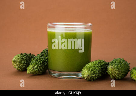 Jus d'herbes d'momodica vert dans un verre avec tranches de légumes, jus de courge amère karela ou jus Banque D'Images