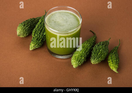 Jus d'herbes d'momodica vert dans un verre avec tranches de légumes, jus de courge amère karela ou jus Banque D'Images