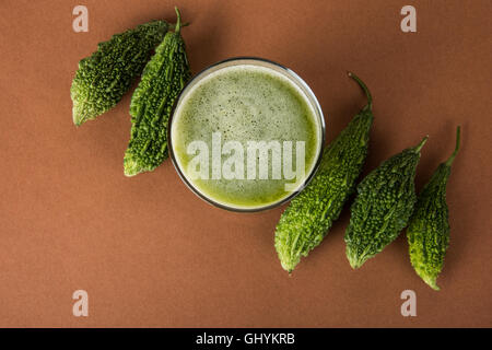 Jus d'herbes d'momodica vert dans un verre avec tranches de légumes, jus de courge amère karela ou jus Banque D'Images