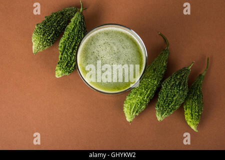 Jus d'herbes d'momodica vert dans un verre avec tranches de légumes, jus de courge amère karela ou jus Banque D'Images