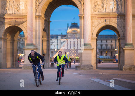 Un tour en vélo laissez-passer de groupe de l'Arc de triomphe du Carrousel et Pyramide du Louvre, au crépuscule, Paris, France Banque D'Images