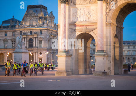 Un tour en vélo laissez-passer de groupe de l'Arc de triomphe du Carrousel et palais du Louvre au crépuscule, Paris, France Banque D'Images