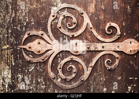 Ancienne forge rouillé sur charnière de porte de décoration vintage wooden board, photo gros plan avec la texture du filtre photo correction tonale rétro Banque D'Images