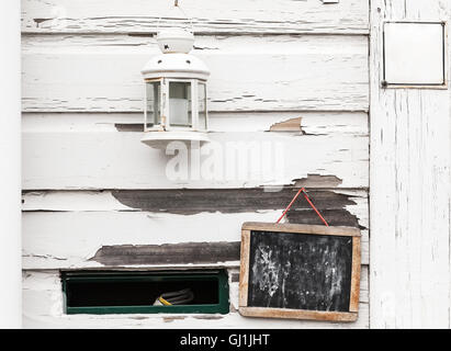 Mur en bois blanches avec tableau noir, lampe bougie et boîte aux lettres trou, texture de fond photo Banque D'Images