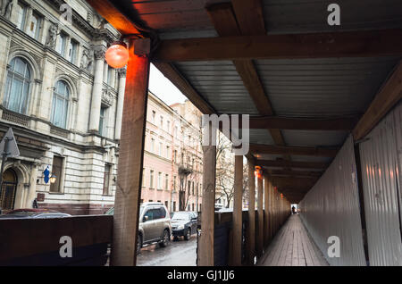 Site de construction avec la lumière rouge d'avertissement, de protection en bois vide corridor le long de la rue pour les piétons Banque D'Images