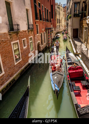 Gondoles passant sur un canal étroit, encombré de Venise, Italie. Banque D'Images