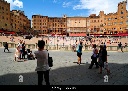 Les touristes sur la Piazza del Campo, célèbre pour la course de chevaux, Il Palio de Sienne, Italie Banque D'Images