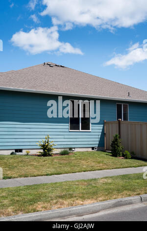 American Suburban home peint en bleu avec des paysages et une nouvelle clôture de cèdre Banque D'Images