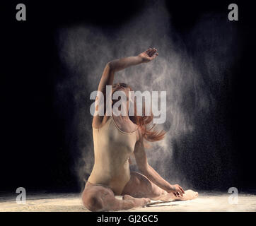 Danseuse allongée par terre dans un ballet posent avec la farine Banque D'Images