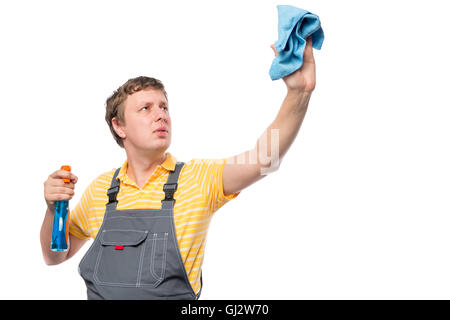 Homme dans un bleu de travail est titulaire d'une bouteille avec vaporisateur et rag sur fond blanc Banque D'Images