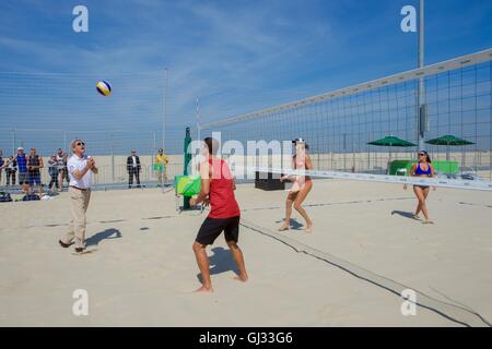 La secrétaire d'Etat John Kerry s'essaie au beach-volley avec l'équipe olympique américaine de beach-volley sur la plage de Copacabana, le 6 août 2016 à Rio de Janeiro, Brésil. Banque D'Images